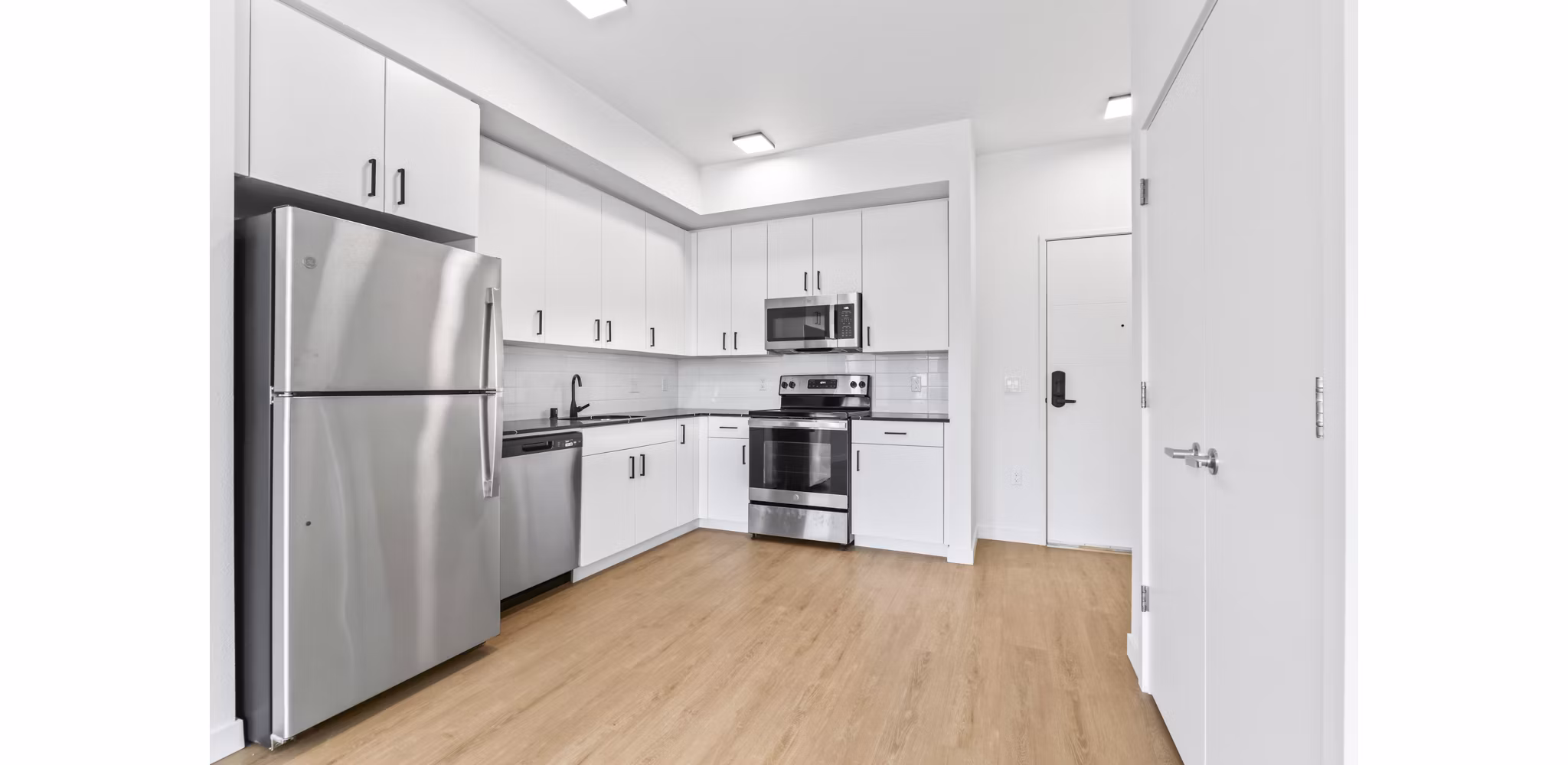 Kitchen with sleek stainless steel appliances at Hudson West Apartments; luxury living space in a Greystar community