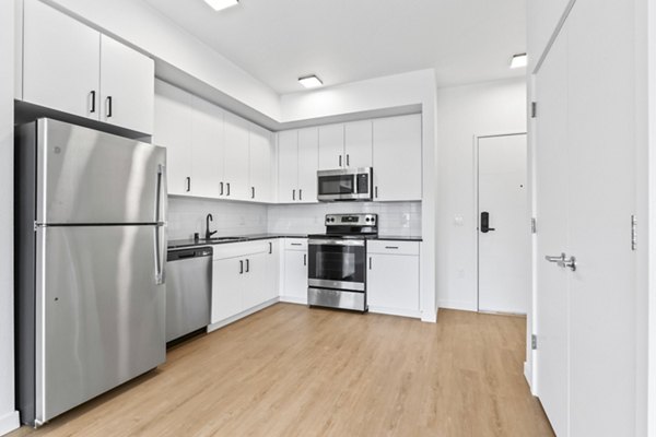 Kitchen with sleek stainless steel appliances at Hudson West Apartments; luxury living space in a Greystar community