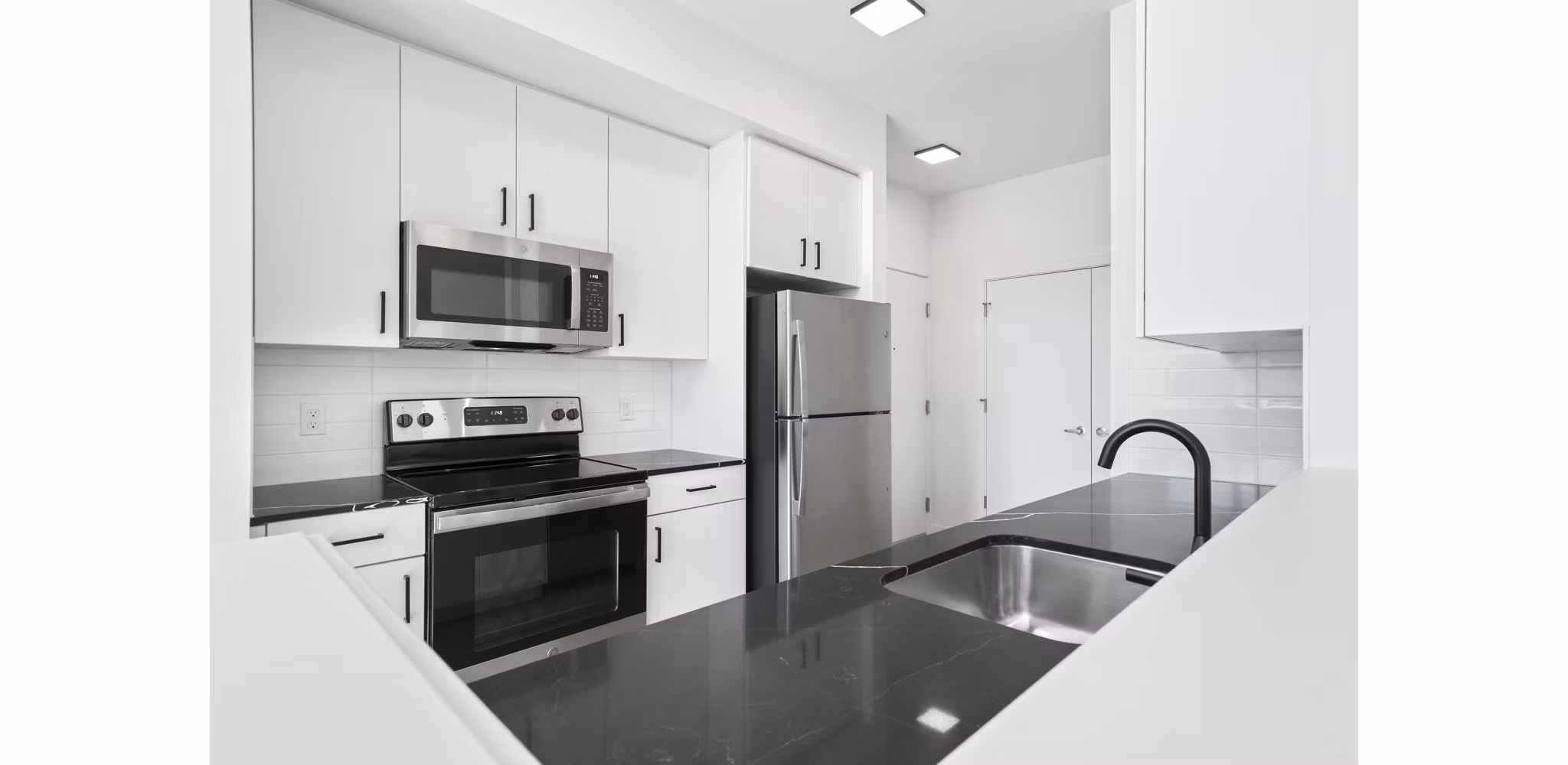 Modern kitchen with stainless steel appliances in Hudson West Apartments