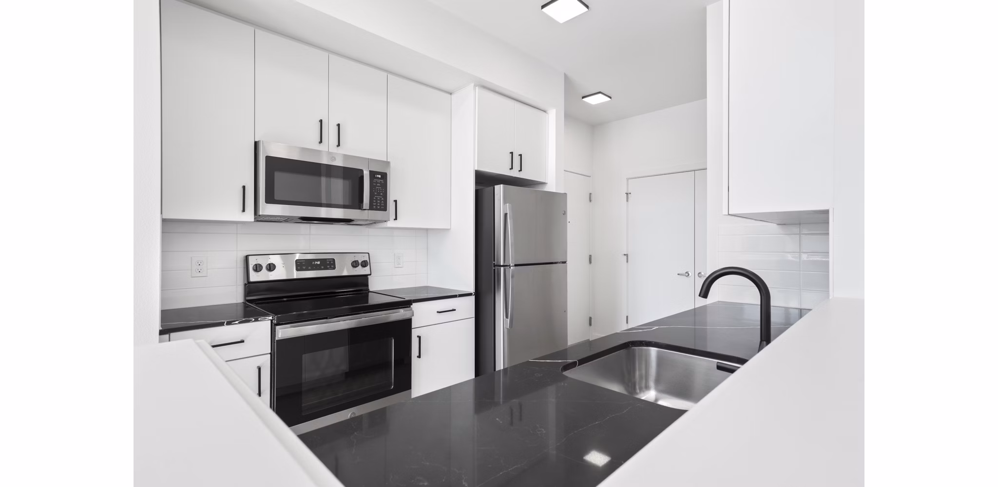 Modern kitchen with stainless steel appliances in Hudson West Apartments