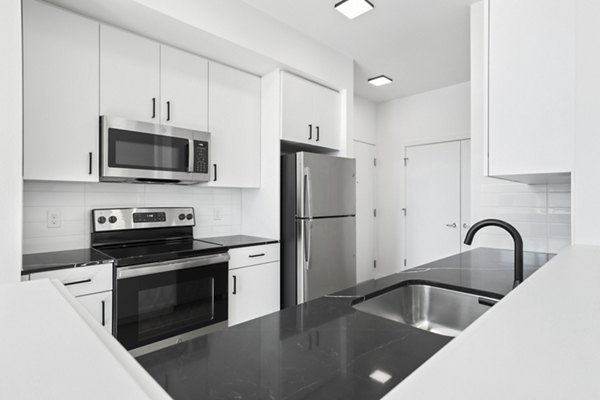 Modern kitchen with stainless steel appliances in Hudson West Apartments