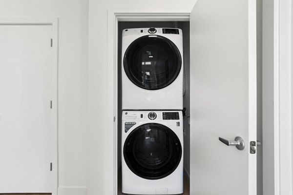 Laundry room featuring modern appliances in Drexler Townhomes at Holbrook Farms