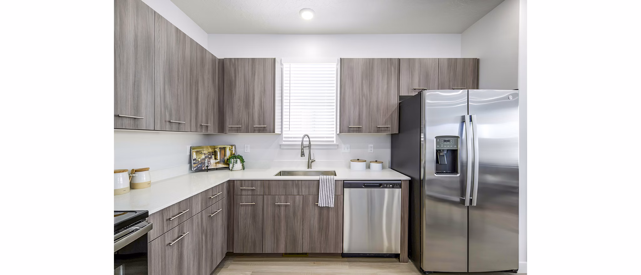 Modern kitchen with stainless steel appliances in Calypso Apartments, featuring sleek countertops and ample cabinetry