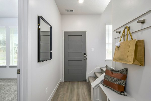 Calypso Apartments: Elegant entry with open stairway leading to a modern living room in luxury community