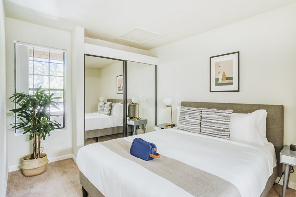 Cozy bedroom with modern decor in Ygnacio Village Apartments, featuring plush bedding and natural light