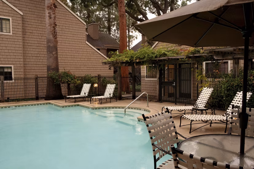 Outdoor swimming pool with sun loungers at Ygnacio Village Apartments
