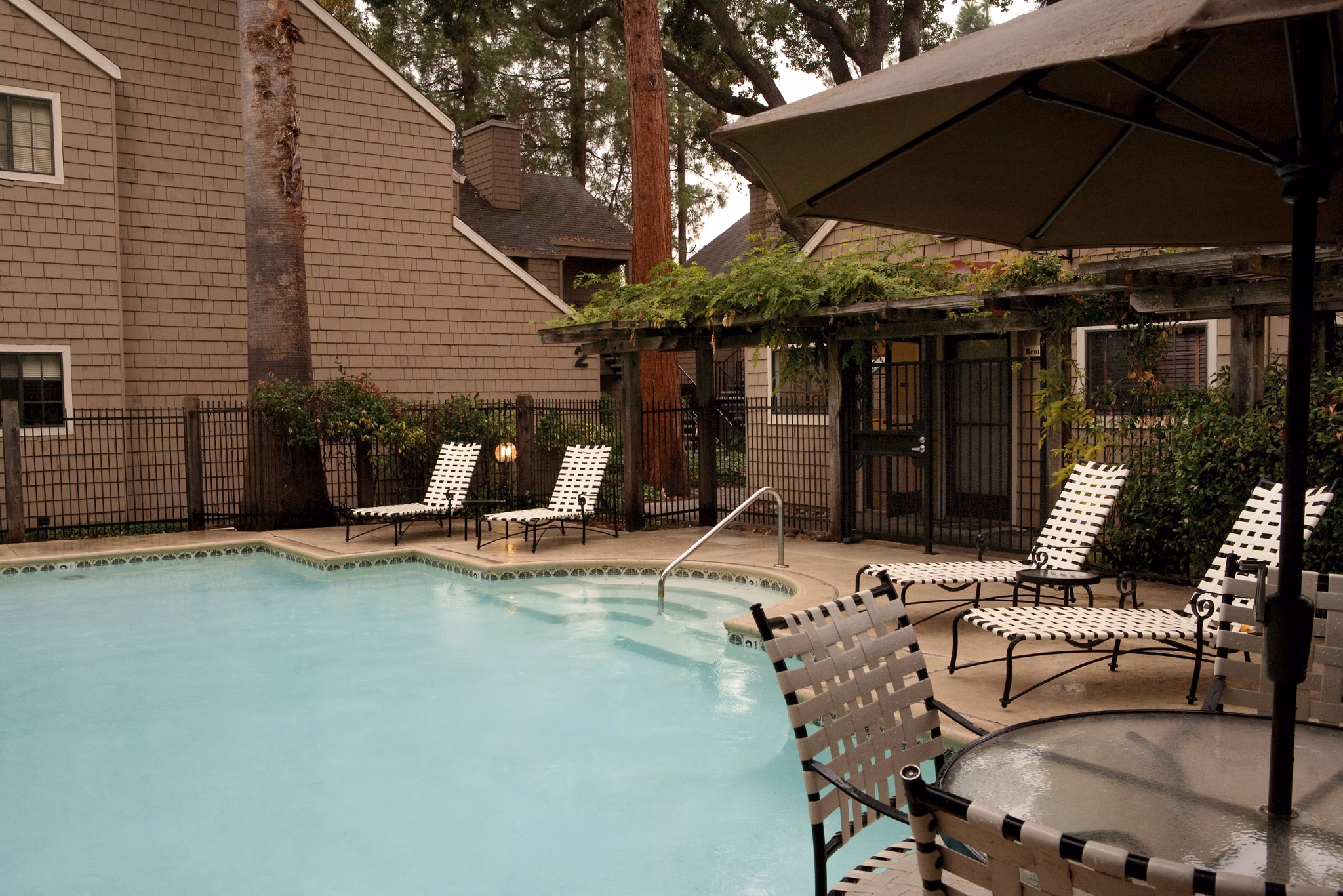 Outdoor swimming pool with sun loungers at Ygnacio Village Apartments