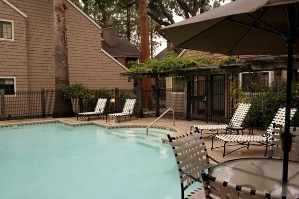 Outdoor swimming pool with sun loungers at Ygnacio Village Apartments