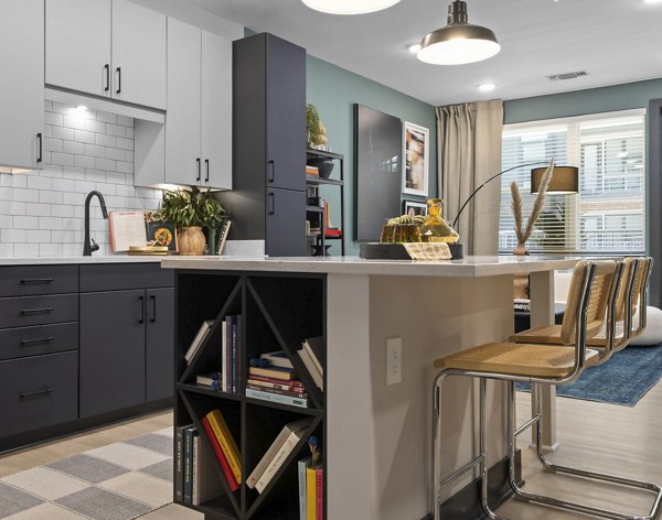 Modern kitchen featuring stainless steel appliances and granite countertops at The Miles Apartments