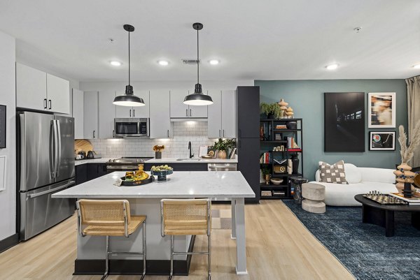 Modern kitchen featuring stainless steel appliances and granite countertops at The Miles Apartments