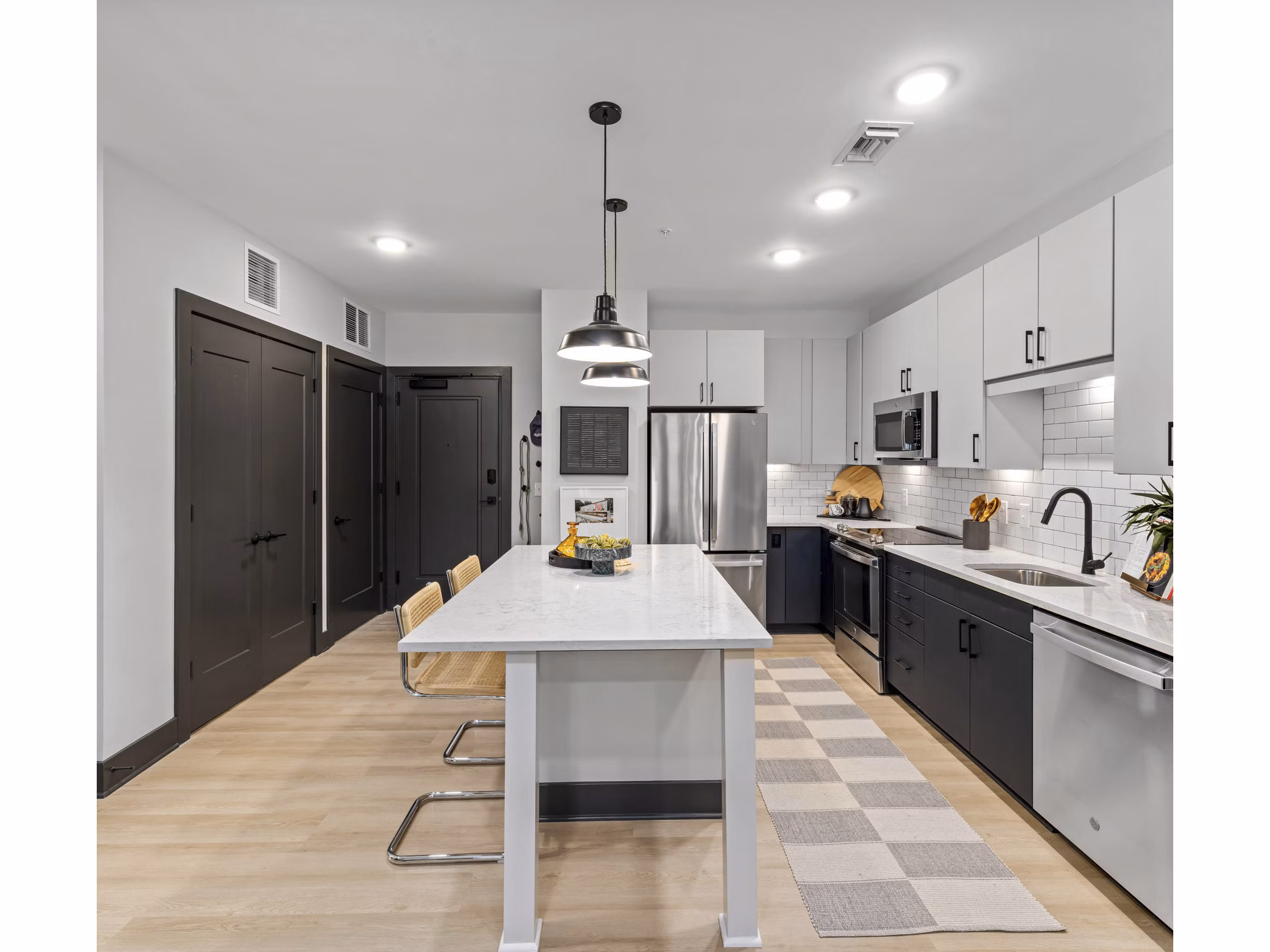 Modern kitchen with stainless steel appliances and granite countertops in The Miles Apartments