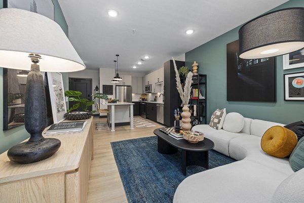 Bright, open-concept living room with modern furnishings at The Miles Apartments