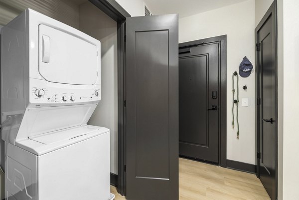 Laundry room with modern appliances at The Miles Apartments offering convenient amenities for residents