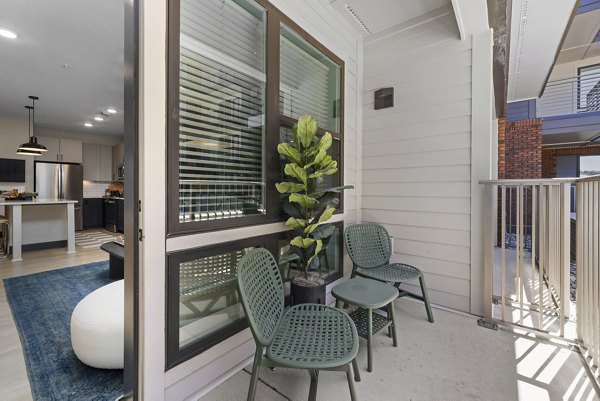 Patio balcony with stylish outdoor seating at The Miles Apartments, offering relaxation and modern living in a luxury community