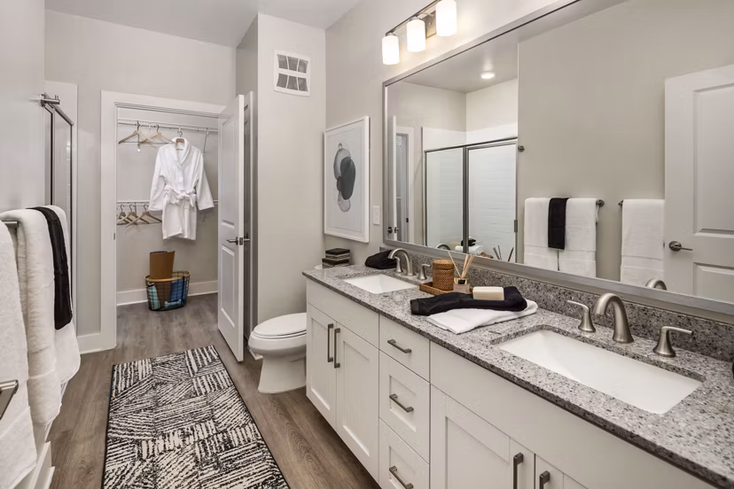 Modern bathroom with dual sinks and tiled walls at Arcadia at Symphony Park Apartments