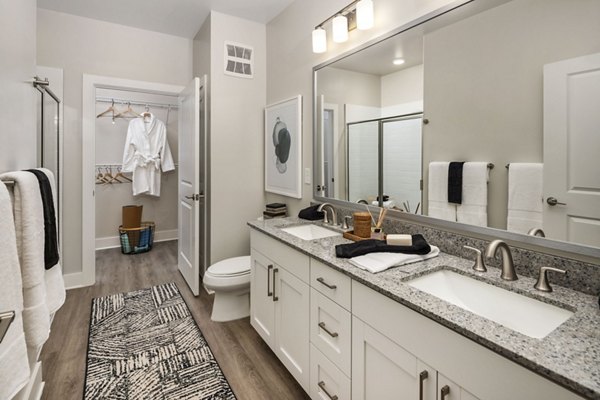 Modern bathroom with dual sinks and tiled walls at Arcadia at Symphony Park Apartments