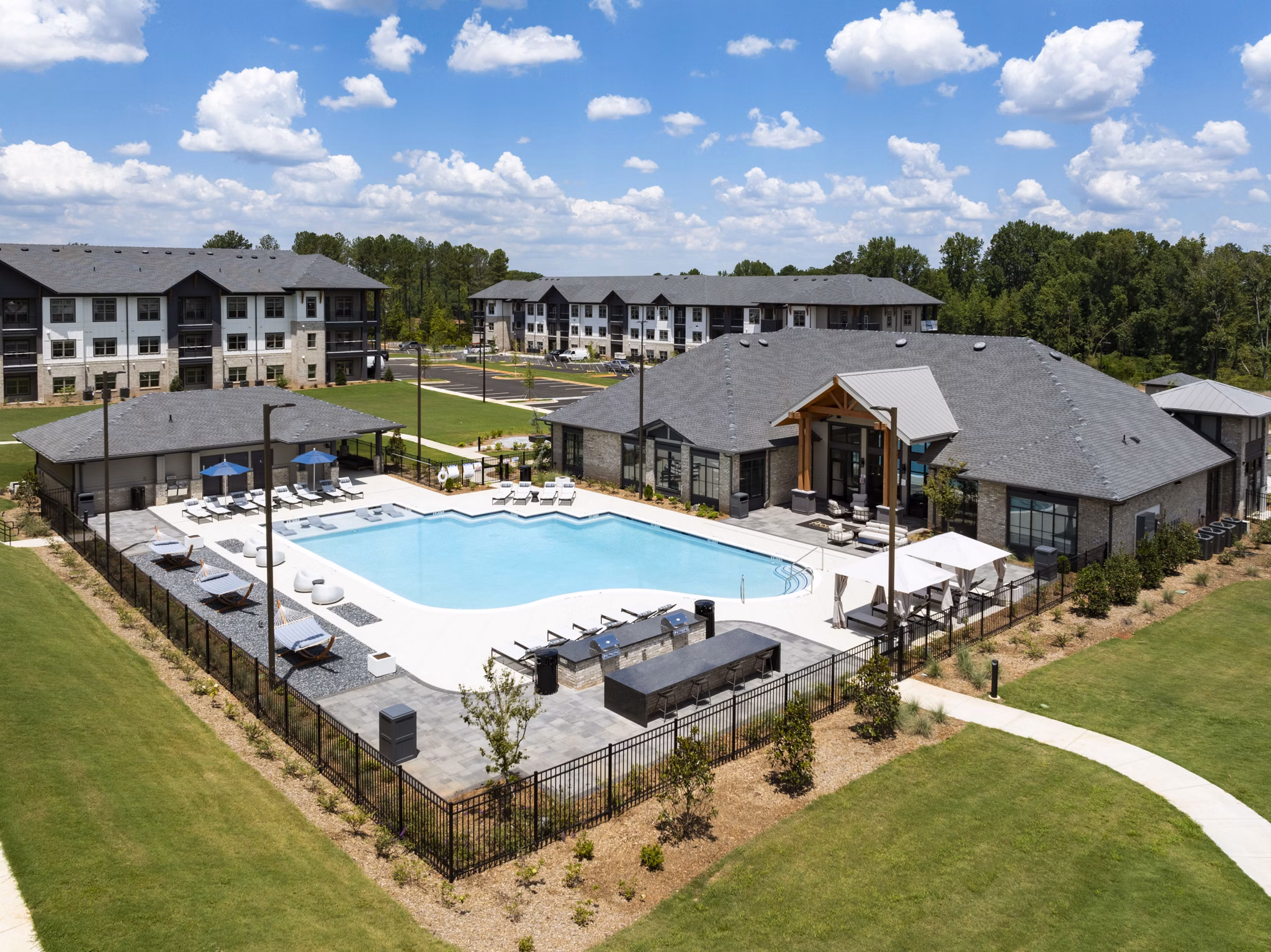 Relaxing poolside area at Arcadia at Symphony Park Apartments with lounge chairs and surrounding greenery