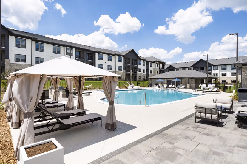 Community swimming pool with sun loungers at Arcadia at Symphony Park Apartments, offering a luxurious and relaxing outdoor space