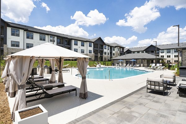 Community swimming pool with sun loungers at Arcadia at Symphony Park Apartments, offering a luxurious and relaxing outdoor space