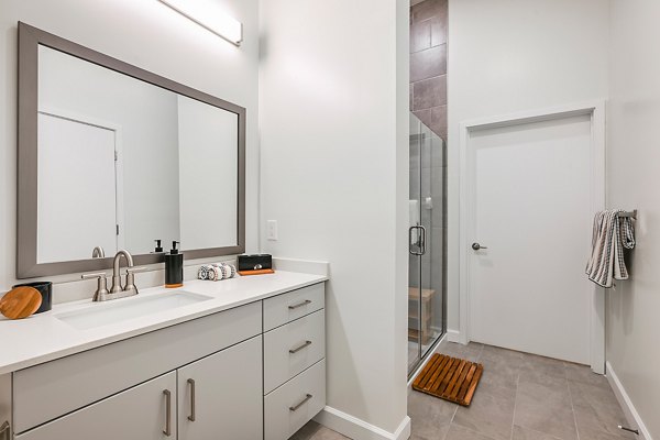 Bathroom with modern fixtures and marble countertops at Apollo Apartments