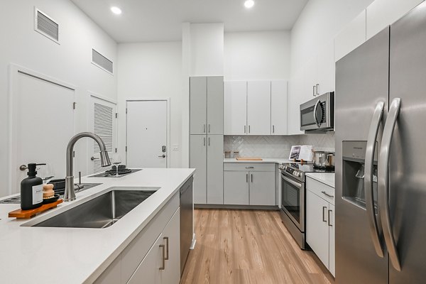 Modern kitchen with stainless steel appliances at Apollo Apartments