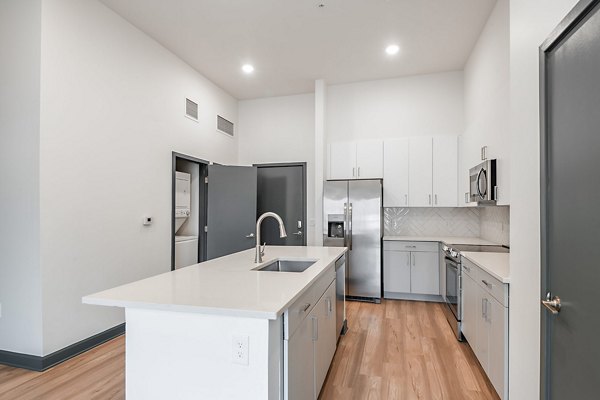 Apollo Apartments: Modern kitchen with stainless steel appliances and sleek countertops