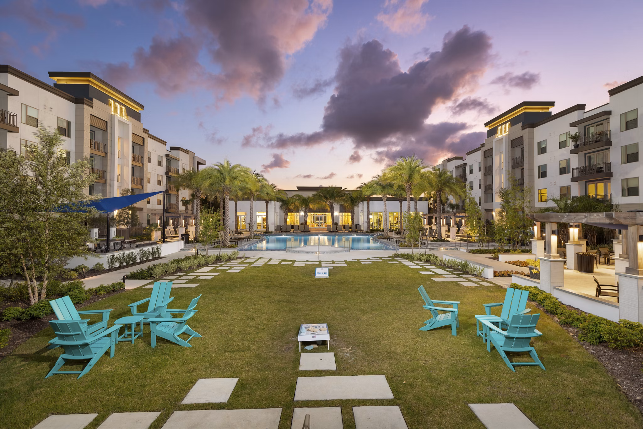 Courtyard featuring lush gardens and seating at SUR Southside Quarter Apartments