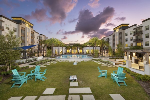 Courtyard featuring lush gardens and seating at SUR Southside Quarter Apartments