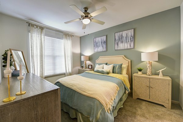 Cozy bedroom with waterfront views at The Views at Harbortown Apartments, featuring stylish decor and ample natural light