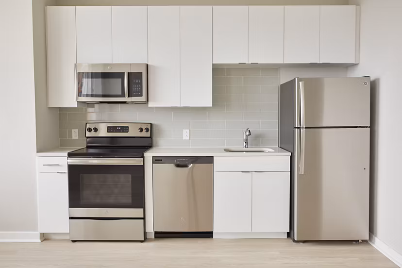 Modern kitchen with stainless steel appliances in The Highline Apartments