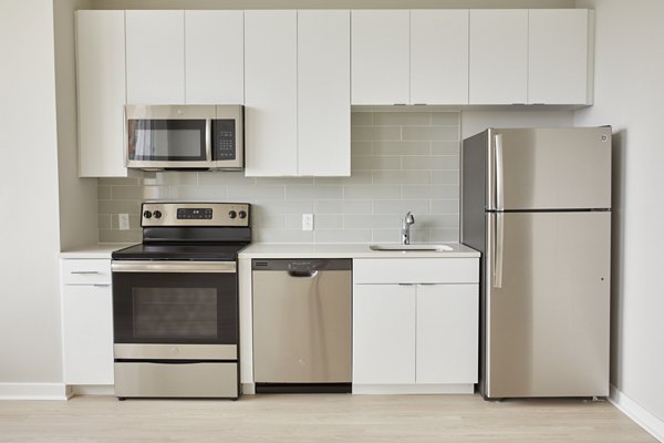 Modern kitchen with stainless steel appliances in The Highline Apartments