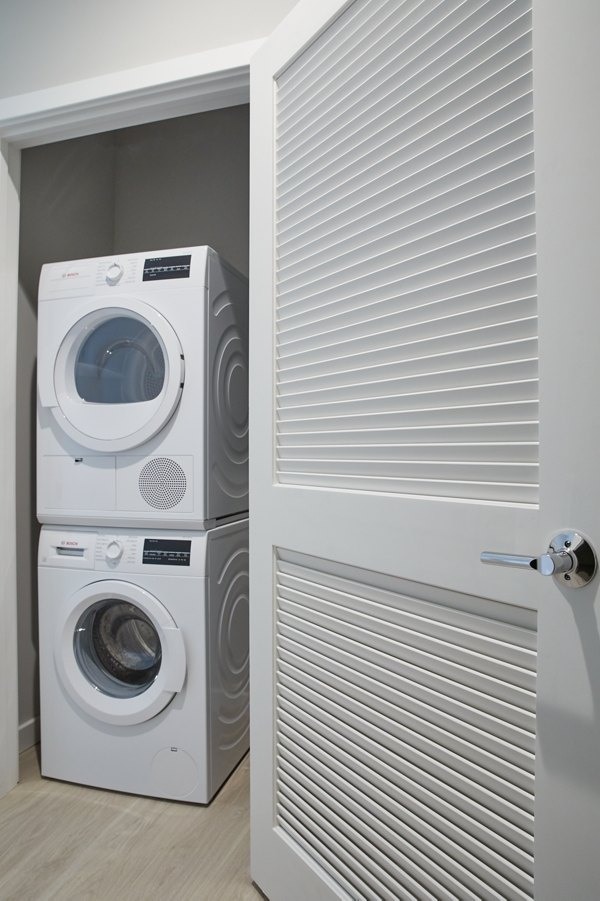 Laundry room with modern appliances in The Highline Apartments, offering luxury amenities and convenient living for residents