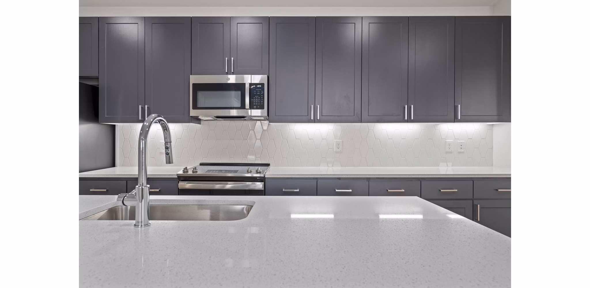 Modern kitchen with stainless steel appliances and granite countertops at Solara Vista Apartments