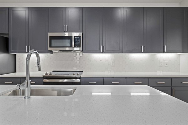 Modern kitchen with stainless steel appliances and granite countertops at Solara Vista Apartments