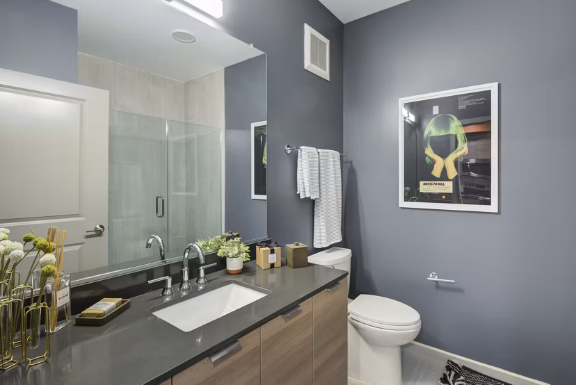 Modern bathroom with marble countertops and glass shower at Union Heights Apartments