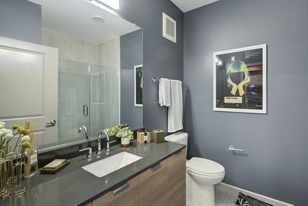 Modern bathroom with marble countertops and glass shower at Union Heights Apartments