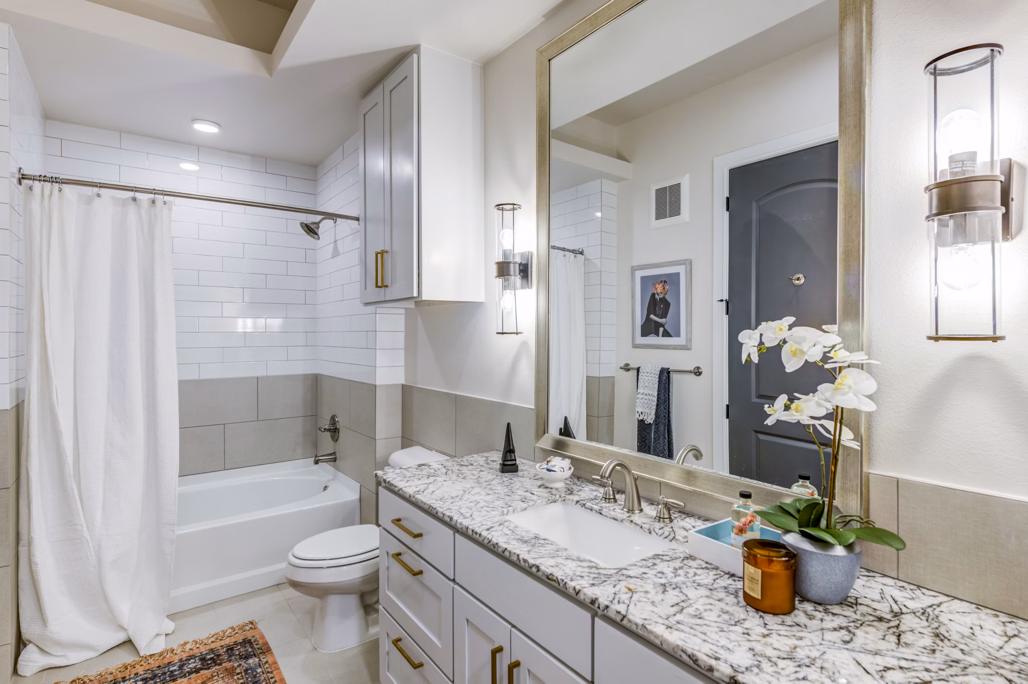 Elegant bathroom with marble countertops and modern fixtures at The Margo Apartments