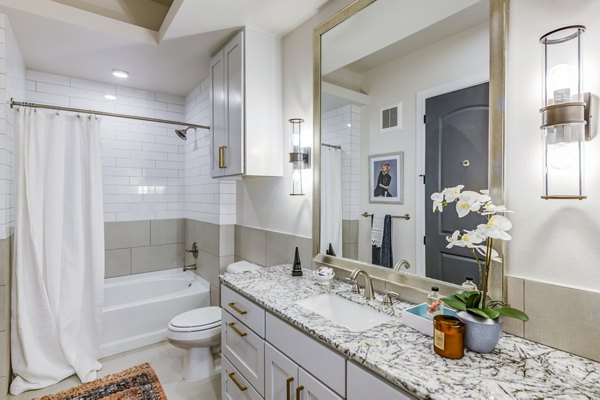 Elegant bathroom with marble countertops and modern fixtures at The Margo Apartments