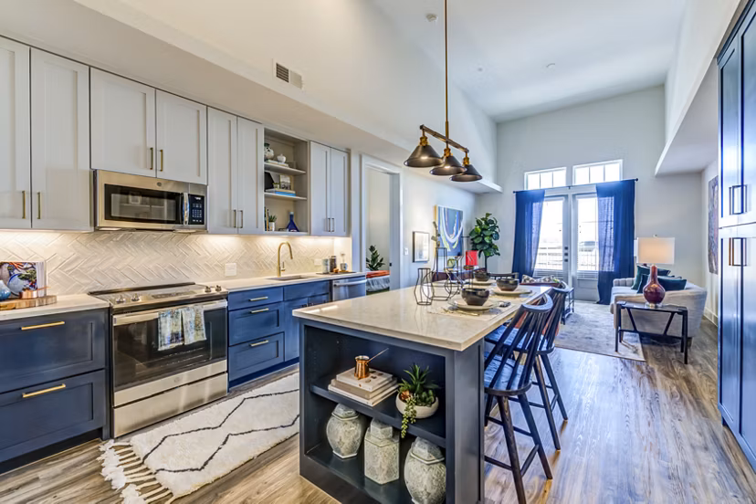 Modern kitchen with stainless steel appliances and granite countertops in The Margo Apartments
