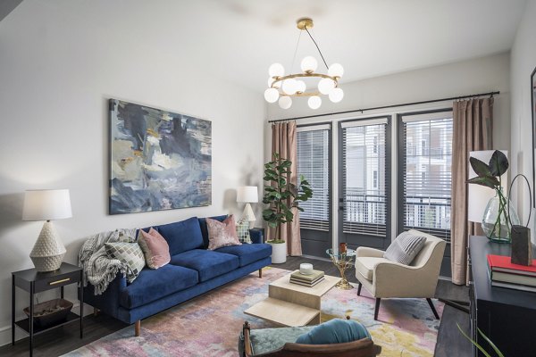 Modern living room with sleek furniture and large windows at The Margo Apartments