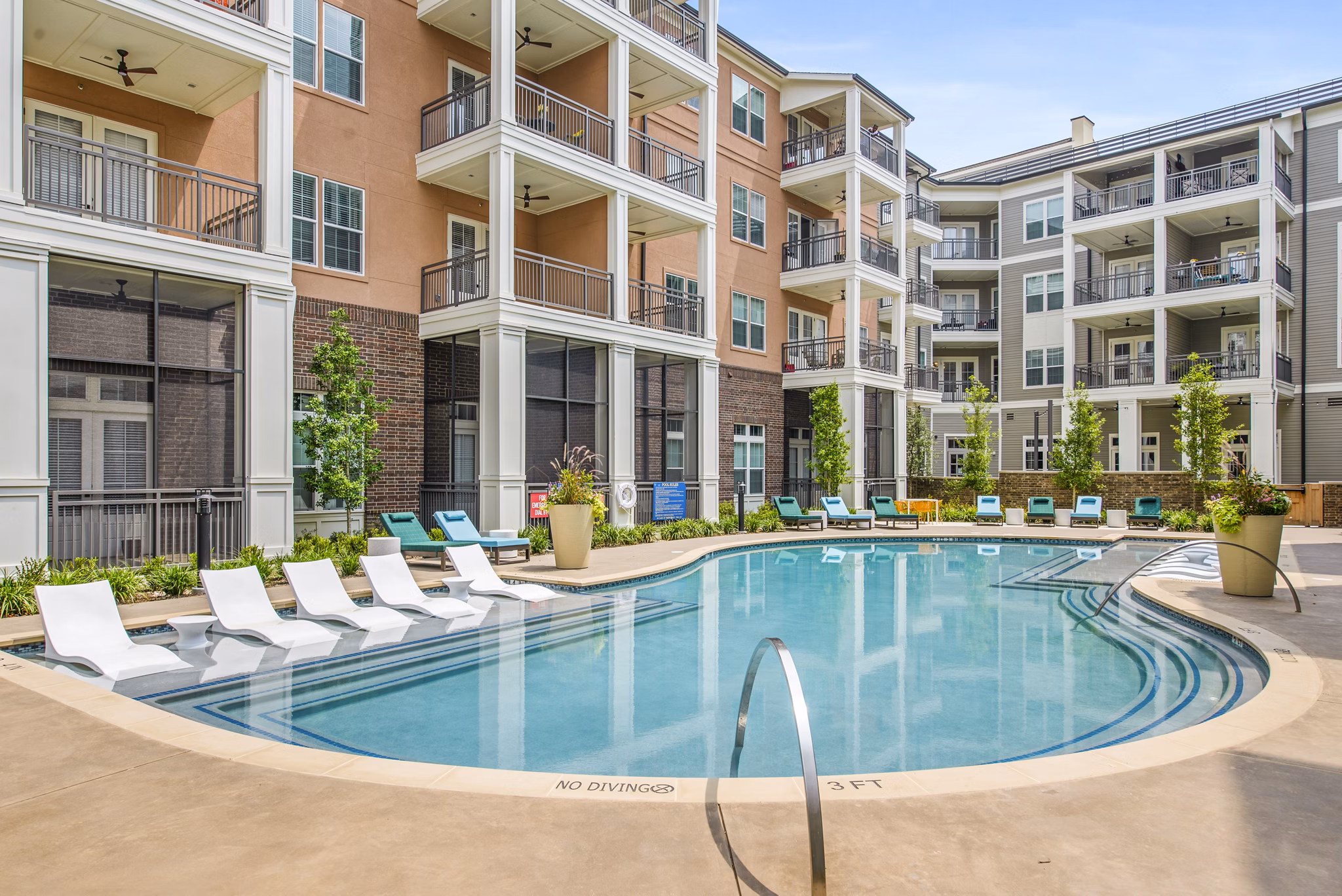 Resort-style pool with lounge chairs at The Margo Apartments, offering a luxury experience in a vibrant community setting