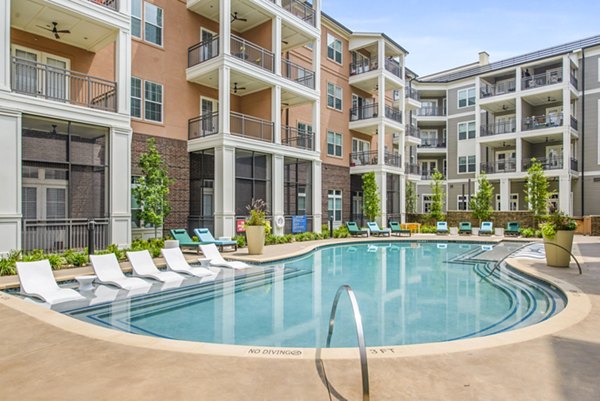 Resort-style pool with lounge chairs at The Margo Apartments, offering a luxury experience in a vibrant community setting