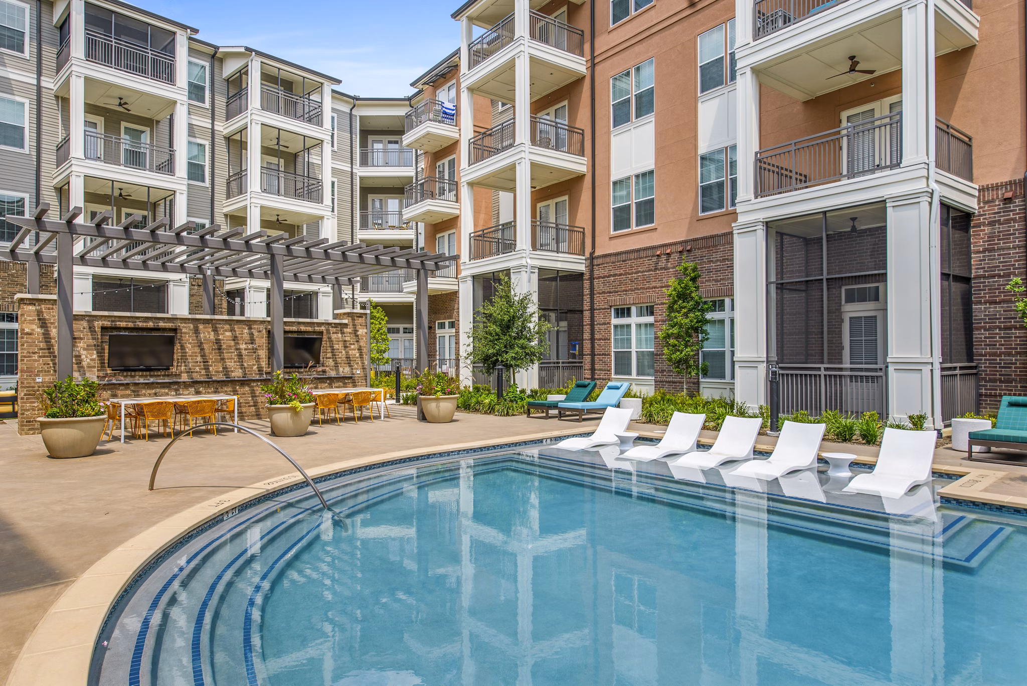 Resort-style pool area with sun loungers at The Margo Apartments