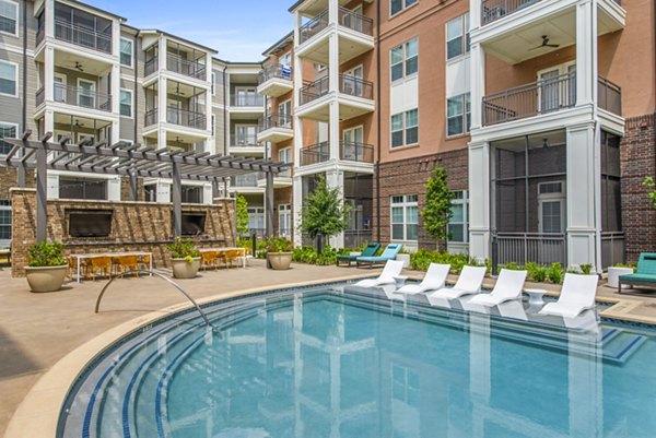 Resort-style pool area with sun loungers at The Margo Apartments