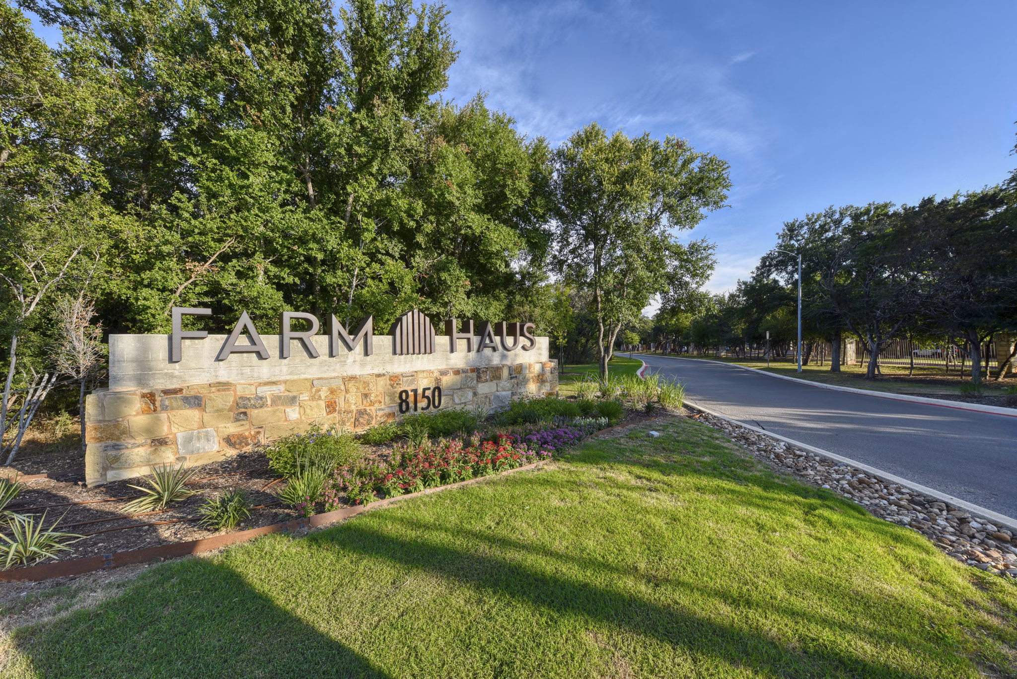 Farm Haus: Stylish signage for luxury rental homes apartment community with lush green surroundings