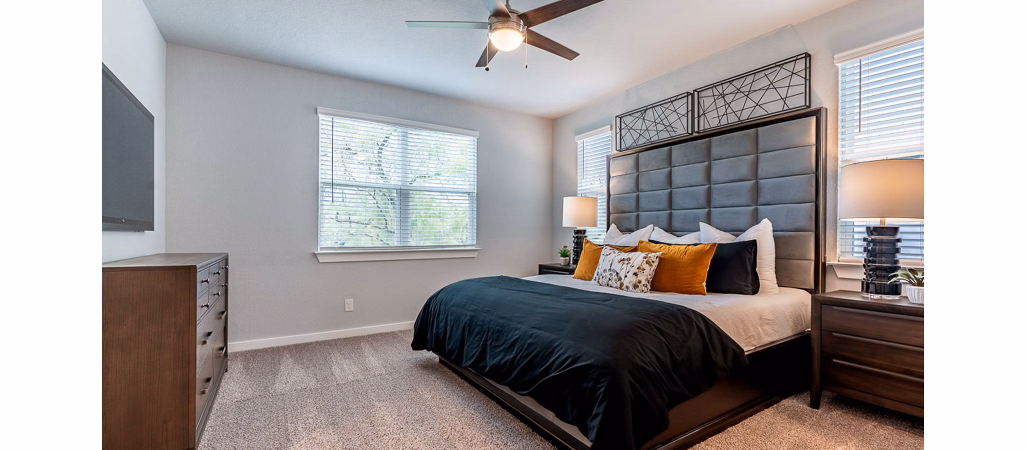 Cozy bedroom with modern decor at Farm Haus Luxury Rental Homes Apartments, featuring plush bedding and soft lighting