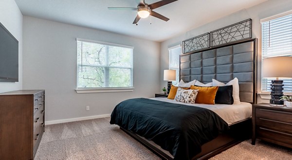 Cozy bedroom with modern decor at Farm Haus Luxury Rental Homes Apartments, featuring plush bedding and soft lighting