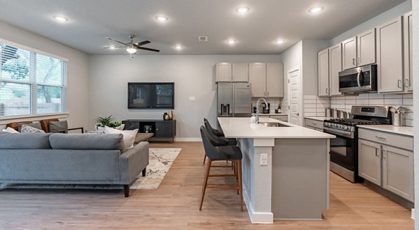 Modern kitchen with sleek appliances and granite countertops at Farm Haus Luxury Rental Homes Apartments