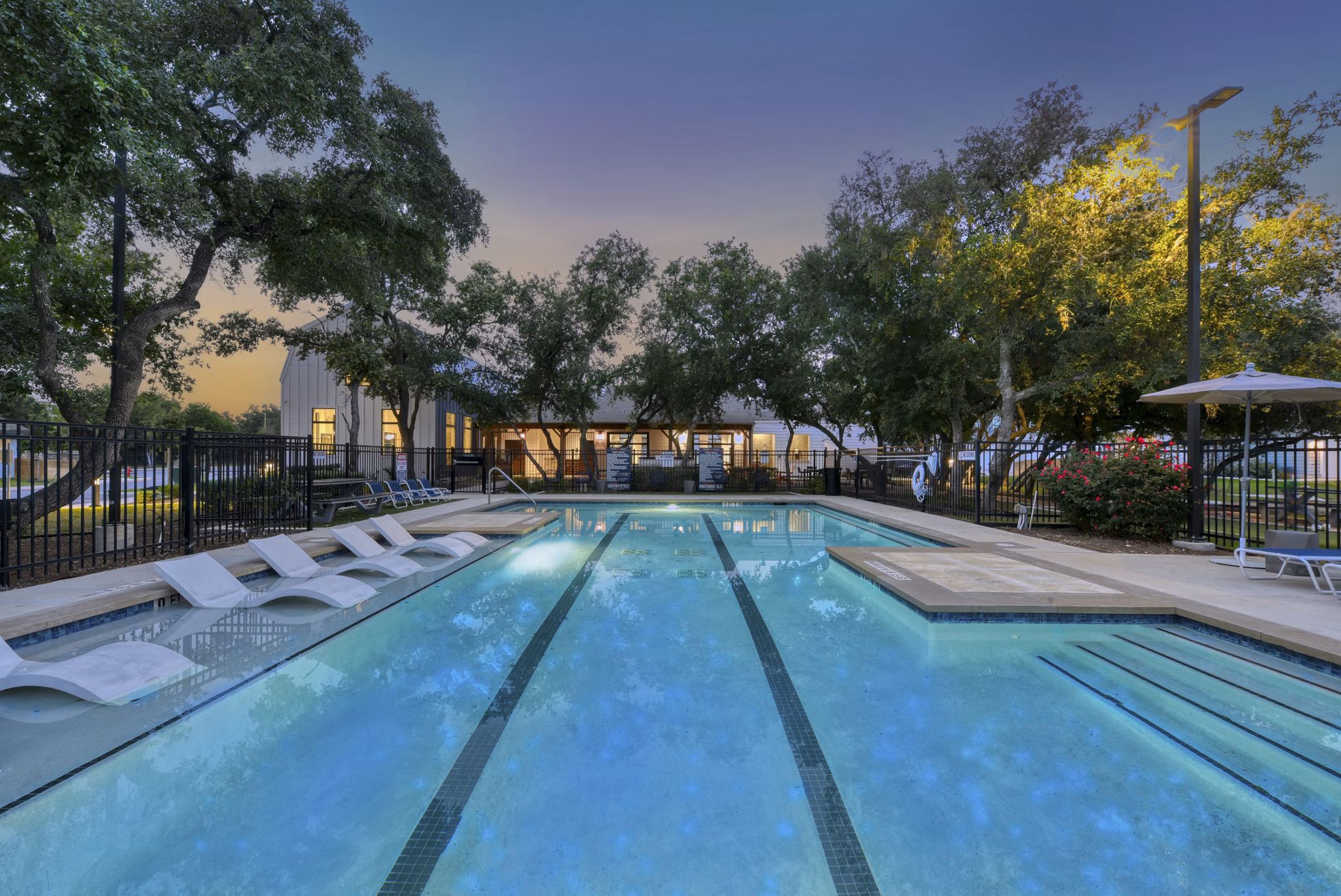 Inviting outdoor pool at Farm Haus Luxury Rental Homes Apartments featuring spacious sun loungers and lush landscaping in a serene setting