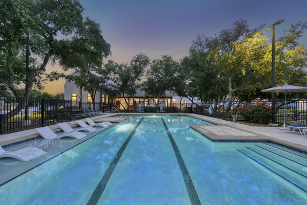 Inviting outdoor pool at Farm Haus Luxury Rental Homes Apartments featuring spacious sun loungers and lush landscaping in a serene setting